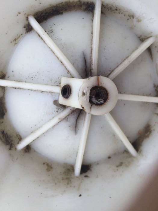 Sprucket fäste på ett fläkthjul från en äldre takfläkt som används för ventilation i ett hus.