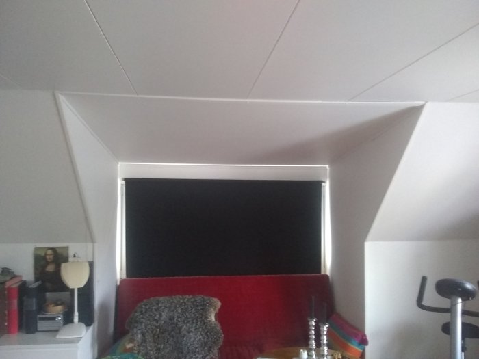 Innertak med synlig sviktning nära rummets hörn ovanför en stor fönsterkupa, med inredning synlig.