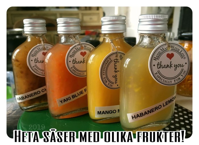 Hemmagjorda heta såser i flaskor med etiketter "Handmade with love thank you", olika färger och smaker.