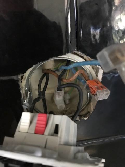 El-installation med bortkopplade kablar och en omkopplare i förgrunden, före montering eller reparation.