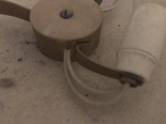 Gammal lampa med sliten elkabel och lamphållare som behöver renoveras.