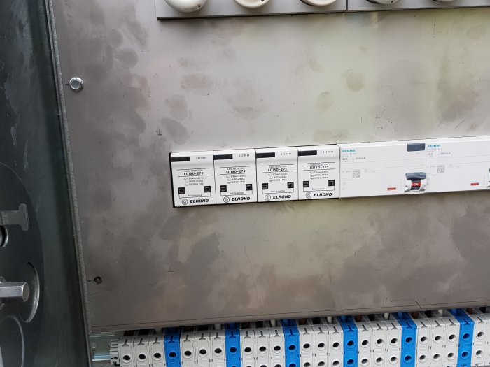 Elektriskt skydd installerat i skåp med märkningar för solcellsanläggning och reservkraftsystem.