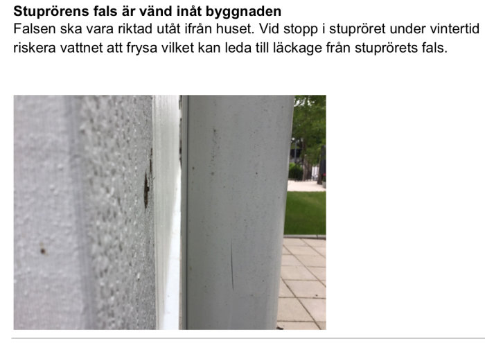 Närbild av ett stuprör med dess fals vänd inåt mot byggnadens vägg, med risk för vatteninträngning och isbildning.