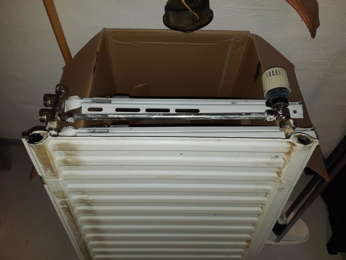 Ett begagnat element med radiatorkopplingar och inlopps-/returrör, radiatorkoppet har synliga M21-gängor.