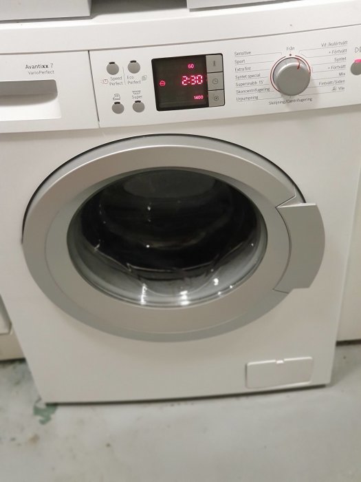 Tvättmaskin i funktion med digital display som visar inställningar och tid.