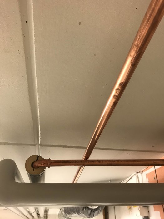 Kopparledning monterad till tak med tejp vid avsedd avkapningspunkt för presskoppling.