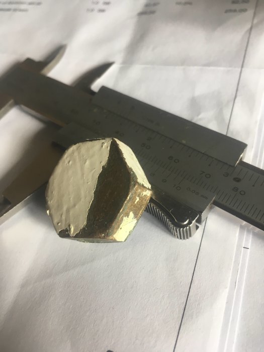 Måttbestämning av ett hexagonalt, gängat täcklock för element med en skjutmått öppen över dess sidor.