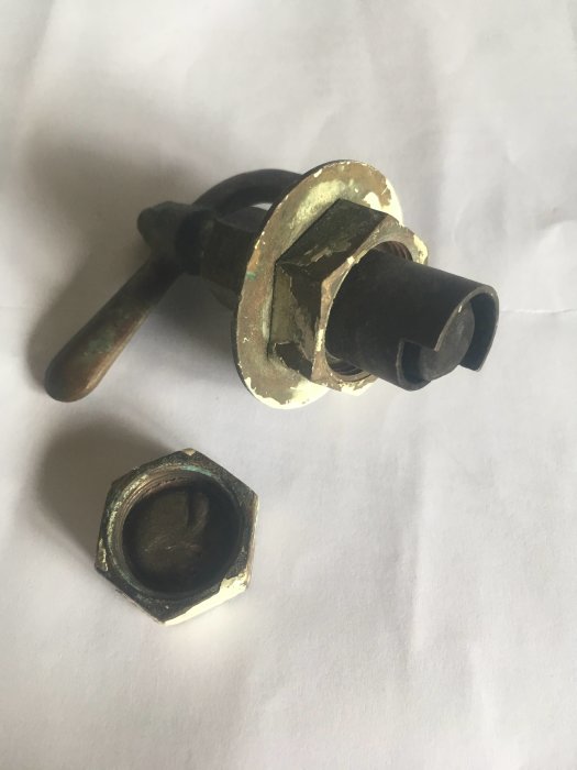 En gammal radiatorventil och ett hexagonalt täcklock från 1955, använda för att ersätta med termostater.