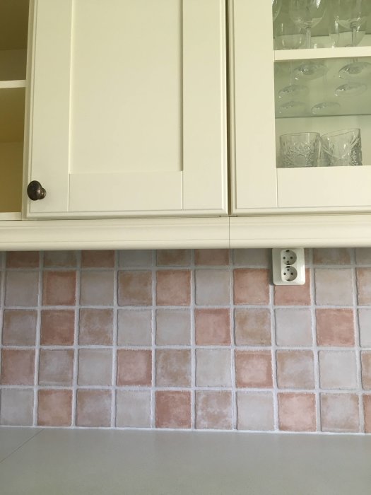 Vit kökslucka med detaljer och kakelvägg i rosa och vitt som söker målningstips.