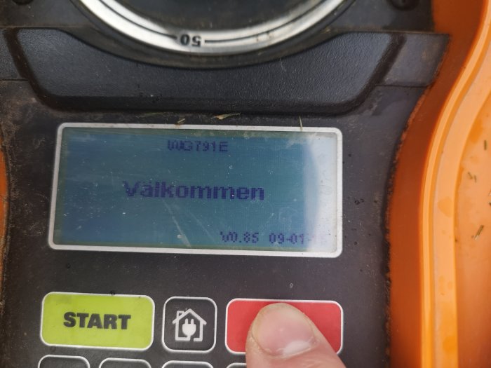 Digital display på en maskin som visar texten "Välkommen" och firmware-version v0.85.