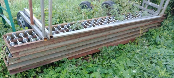 En lång, begagnad vedklipps elevator stående i grönska, utan den sålda betongblandaren synlig.