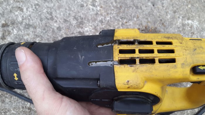 Begagnad DeWalt borrhammare med läckande oljig vätska vid ventilationsgallret.