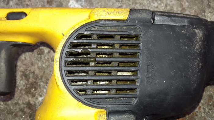 Närbild på en DeWalt borrhammare D25304K med läckage av oljig sörja från ventilationsgallret.