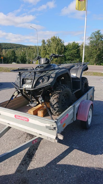 ATV Keeway 300 gtx med lossnat höger framhjul, lastad på släpvagn under dagsljus.