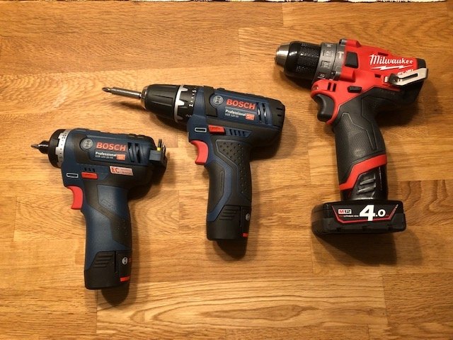 Tre borrmaskiner på trägolv, från vänster Bosch 12V, Bosch 12V-20 HX och Milwaukee M12 Fuel.