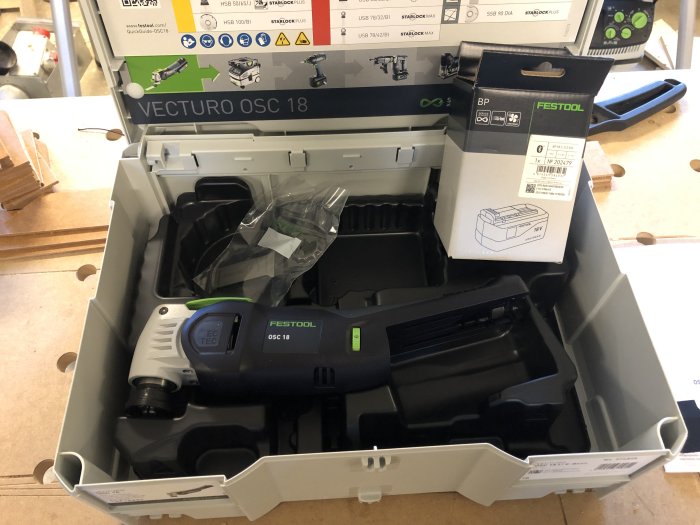 Ny Festool VECTURO OSC 18 multiverktyg i öppen låda med extra batteri vid sidan.