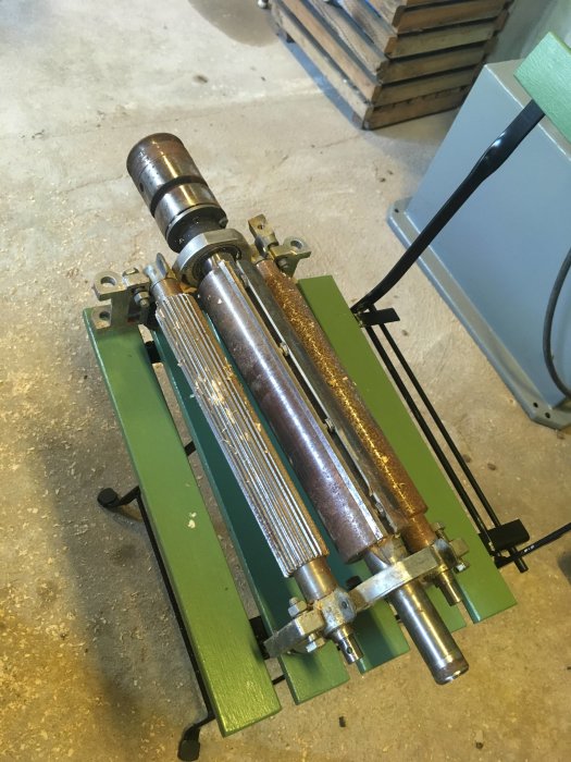 Demonterat kutterpacket från en REMA DYMC-8 kombimaskin med synliga rostfläckar och smuts på en verkstadsbetonggolv.