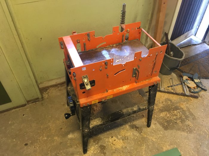 Delvis demonterad orange och svart kombimaskin REMA DYMC-8 i en verkstad.