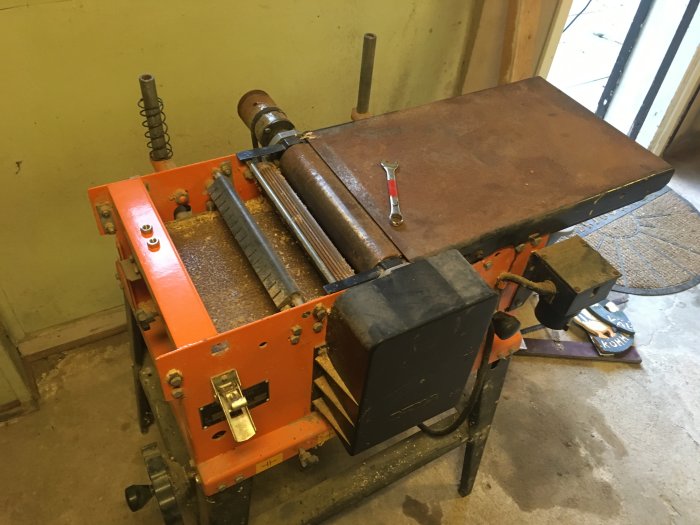 Använd kombimaskin för träbearbetning med rostiga delar står i ett verkstadsutrymme, redo för demontering och renovering.