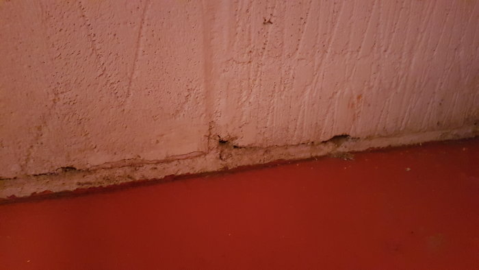 Vägg och golvskarv med synligt hål och tätning i ett utbyggnadsprojekt.