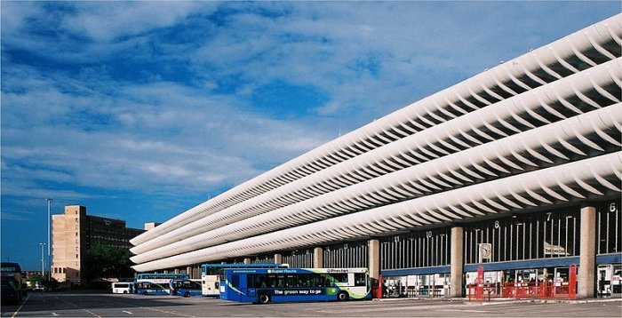 Brutalistisk arkitektur av Preston Bus Station i Storbritannien med distinkta vågformade tak och bussar framför.