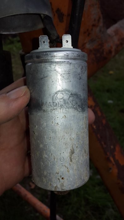 Sliten kondensator med specifikationen 12 uF 450 V otydligt märkt, demonterad från maskin.