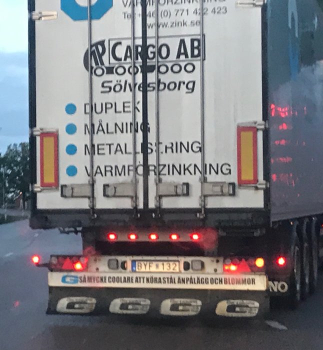 Lastbil med text "SÅ MYCKET COOLARE ATT KÖRA STÅL ÄN PÅLÄGG OCH BLOMMOR" på bakdörren.