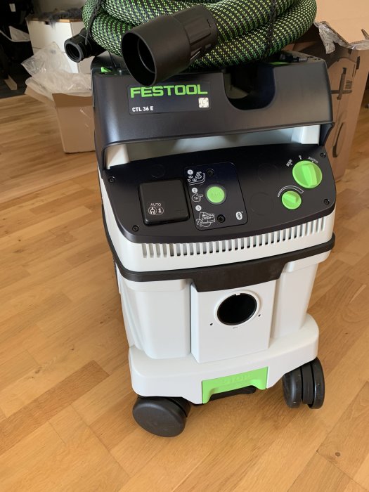 Festool dammsugare CTL 36 E med bluetooth på ett trägolv, omgiven av förpackningsmaterial.