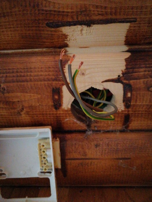 Avslöjade el-kablar vid en vägg där panel tagits ner, med en öppen anslutningsdosa redo för ubåt eller klämma.