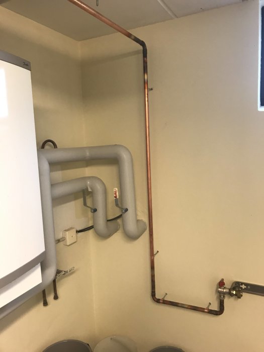 Installation av kopparledningar och väggfästen för VVS-projekt, allt monterat i våg och lod.