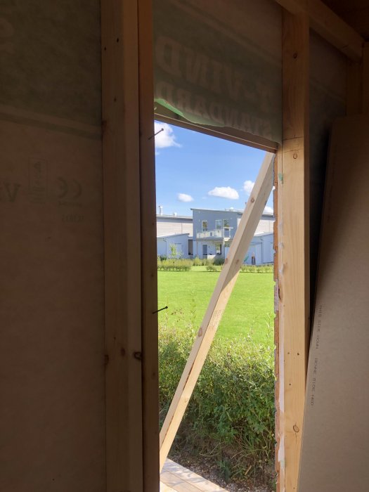 Nyligen installerat fönster i byggkonstruktion med utsikt över gröna omgivningar.