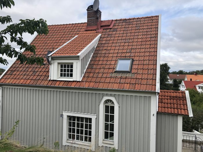 Exteriör av nyklassicistiskt hus i Göteborgstrakten med tegeltak och ej originalfönster.