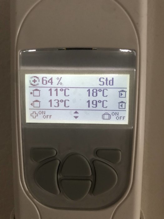 Display på värmepumpen visar driftinformation med temperaturer och fuktighet på 64%.