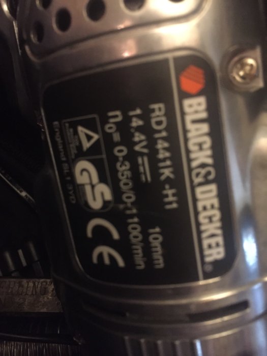 Närbild av en Black & Decker-specialutgåva borrmaskinetikett med specifikationer, suddig i rörelse.