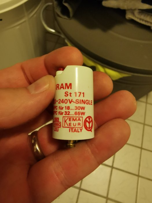 Hand håller en glimtändare för lysrör, Osram ST 171, för 30-65Watt med detaljerad etikett.