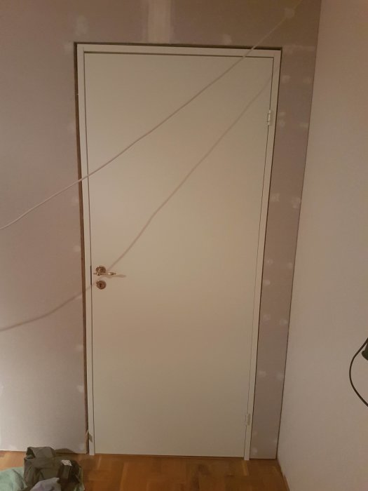 Nyinstallerad innerdörr med synbar glipa i övre och nedre hörn.