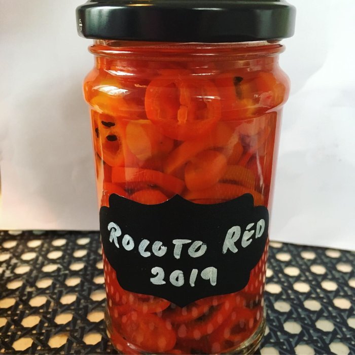 Burk med heminlagda röda Rocoto-chilis, märkt "Rocoto Red 2019".