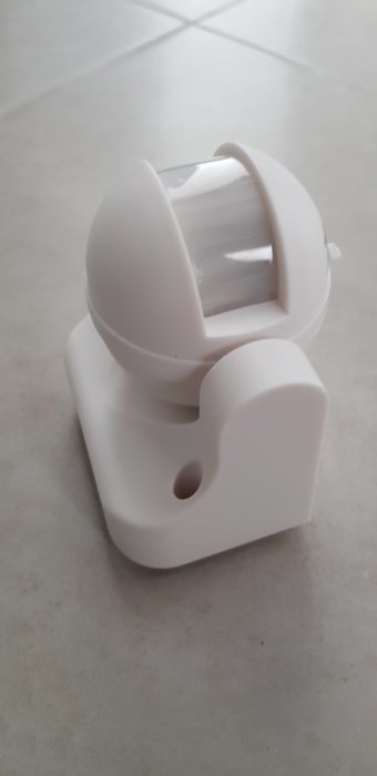 Vit plastbehållare med genomskinligt fönster, möjligen en dispenser eller sensor.