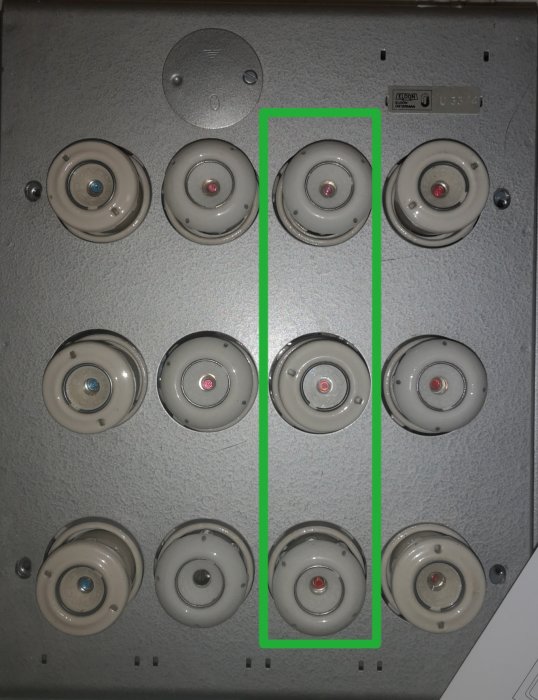 Elektriskt skåp med säkringsdosor, grönt markerat område visar faserna med spänning mot nollan.
