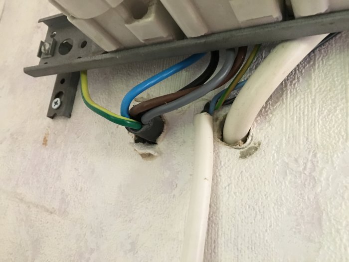 Elkablar går in i ett proppskåp med fokus på den svarta kabeln som nämns i inlägget.