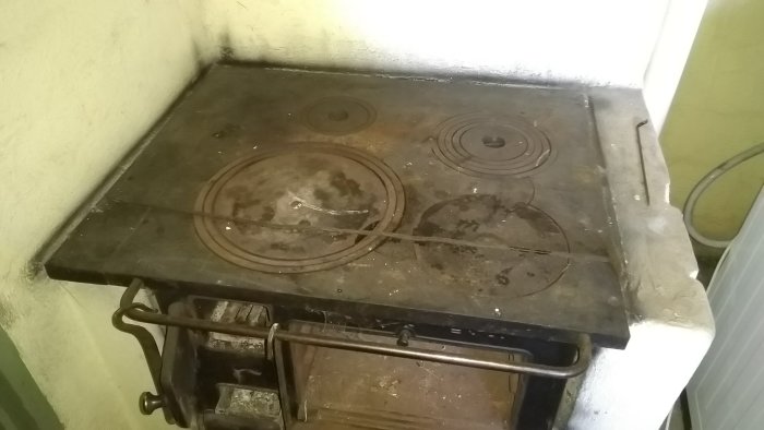 Gammal och smutsig spisplatta i ett kök med synliga tecken på kraftig användning och slitage.