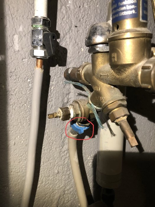Rörledningar och ventiler med röd cirkel markerande tvättmaskinens vattenslanganslutning.
