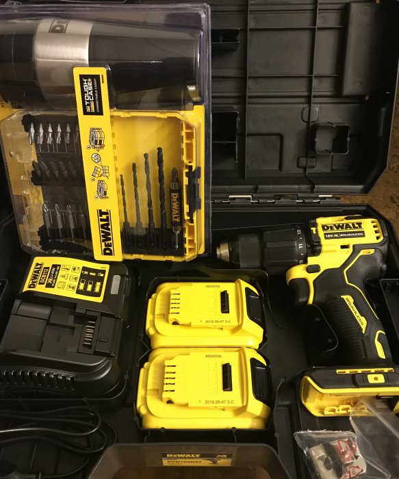 DeWalt borrskruvdragare med tillbehör och batterier i en öppen verktygsväska.