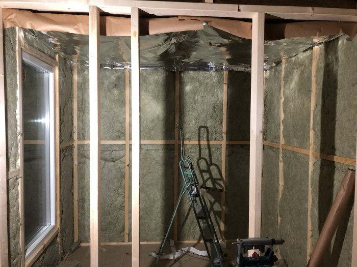 Inbyggnadssteg av en bastu med isolering mellan reglar på väggar och i tak, ingen taklampa, endast väggbelysning planeras.