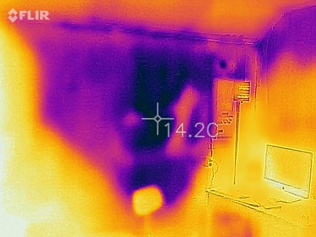 Termisk bild på en vägg med varierande värmeområden, visade med FLIR-kamera, som används för att upptäcka isoleringsbrister.