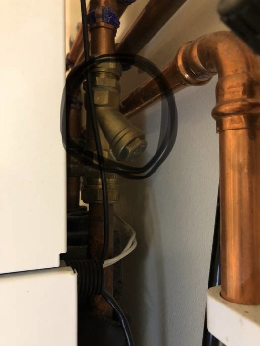 VVS-installation med stängd pump och synlig mutter för rengöring av filter.