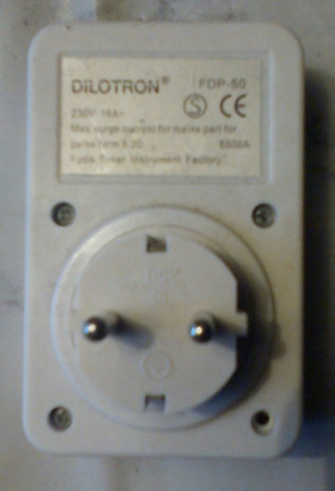 Ett eluttag med en ej lysande röd lampa, eventuellt trasig, otydliga komponenter inuti.