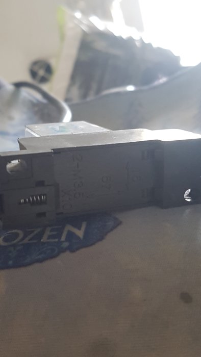 Elektrisk anslutningsmodul med otydliga etiketter och en bakgrund av odefinierat material.