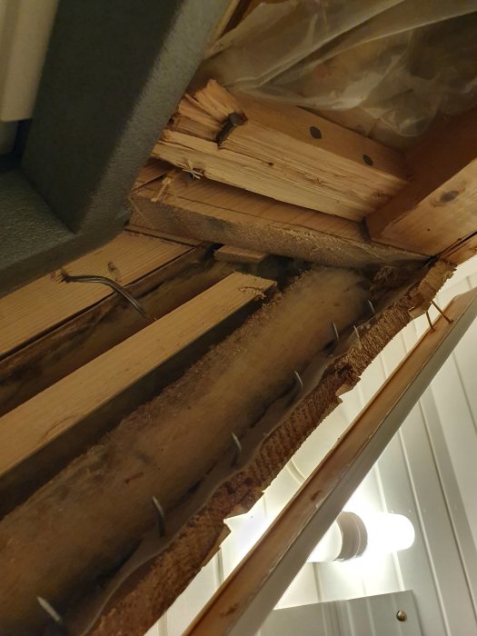 Takstol med avkapade delar nära nytt Velux takfönster under installation.