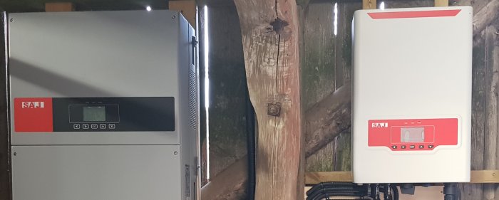 Två SAJ-omformare för solenergiinstallation monterade på en trävägg.